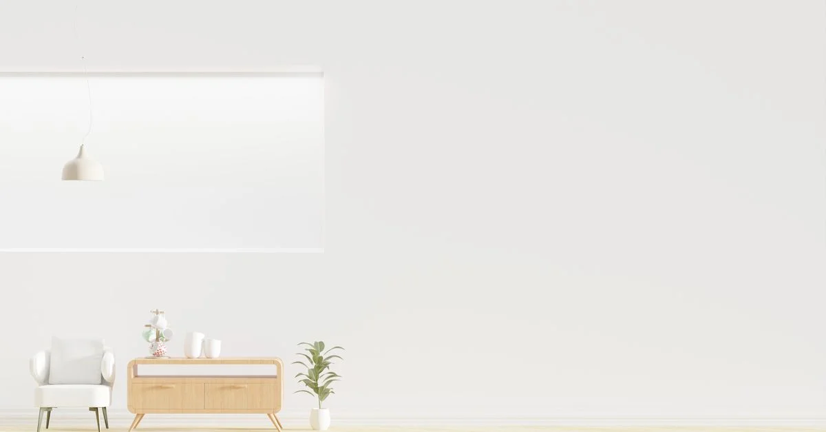 Chambre lumineuse et minimaliste avec un fauteuil, une commode en bois et de la verdure.