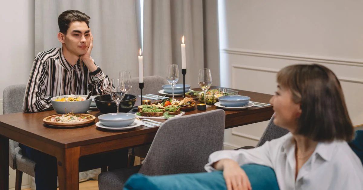 Deux amis profitent d'une expérience de repas décontractée avec une table magnifiquement dressée à l'intérieur.